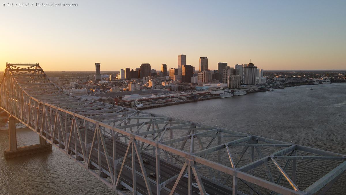 Aerial view along the Crescent City Connection bridge truss toward the downtown New Orleans skyline at sunset, Louisiana
