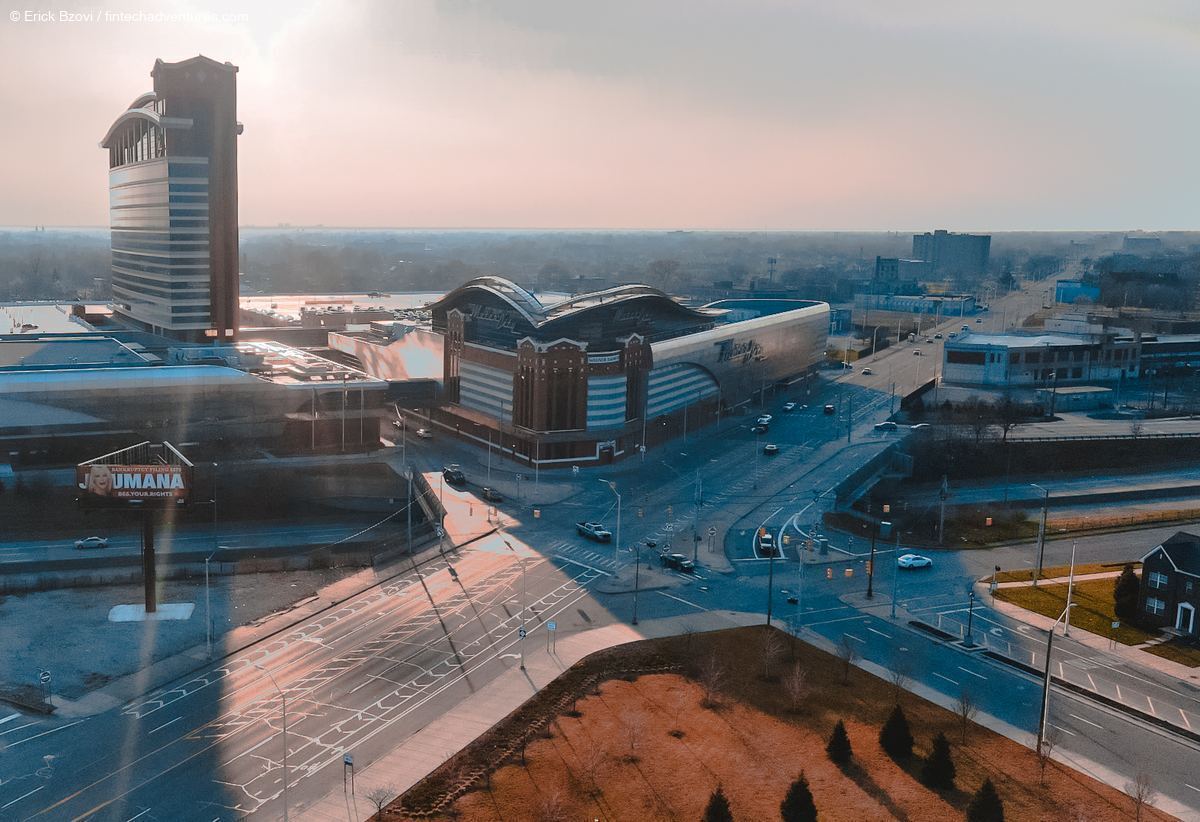 Aerial drone view of MotorCity Casino Hotel and surrounding Detroit cityscape at golden hour with lens flare