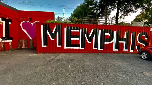I Love Memphis mural painted in black and white letters across a red shipping container beside a red wall, Memphis, Tennessee