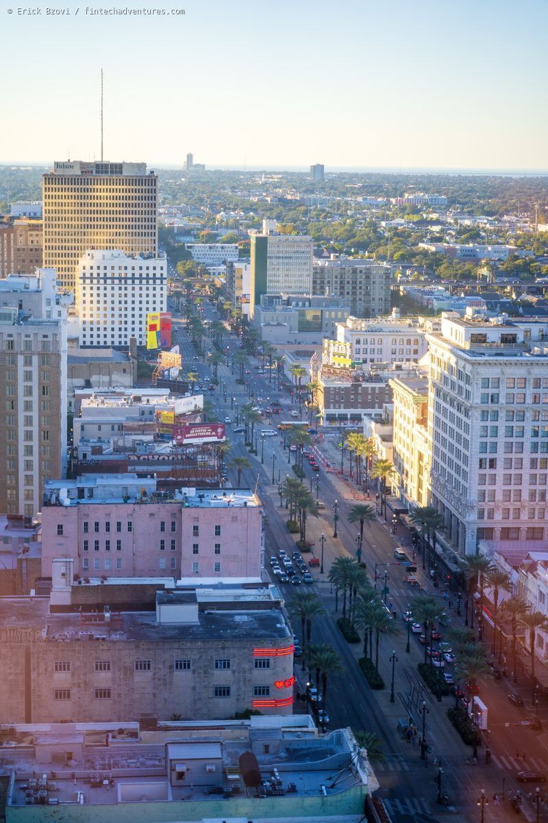 Aerial view of Canal Street at golden hour with palm trees and downtown buildings, New Orleans, Louisiana