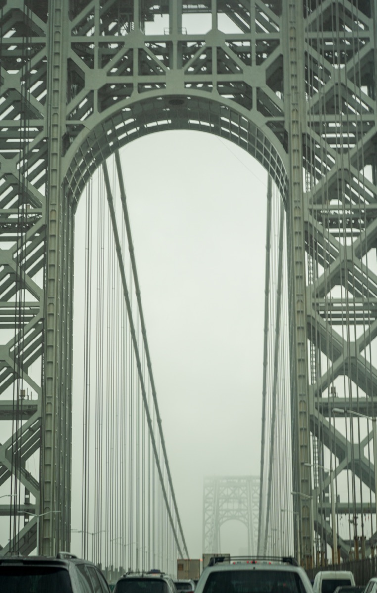 Foggy traffic framed by the steel towers and cables of a Hudson River bridge near Yonkers, New York